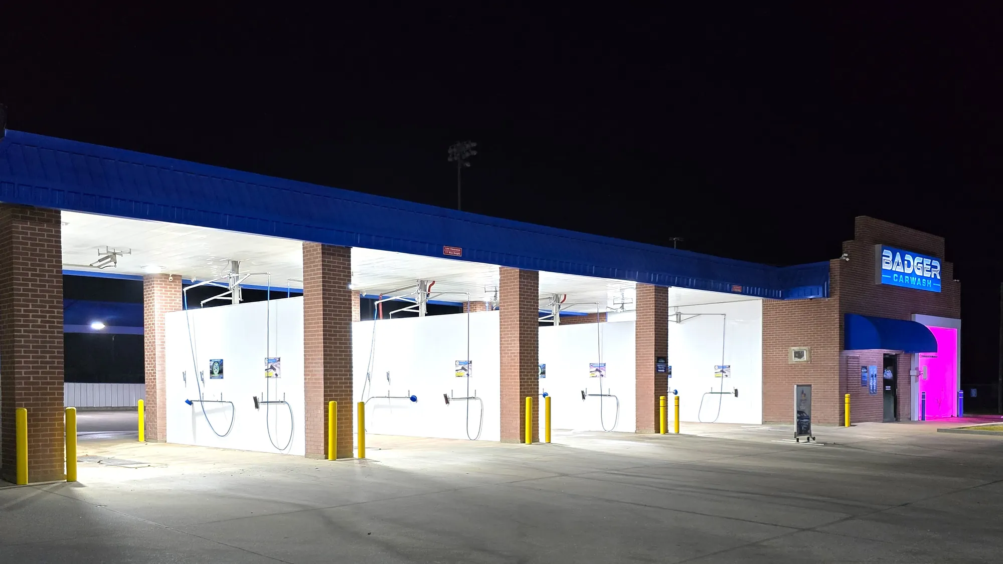 Clean, illuminated self-serve wash bays at Badger Carwash in Lampasas